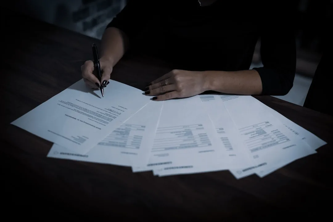 Sole trader reviewing receipts and a laptop spreadsheet of allowable business expenses