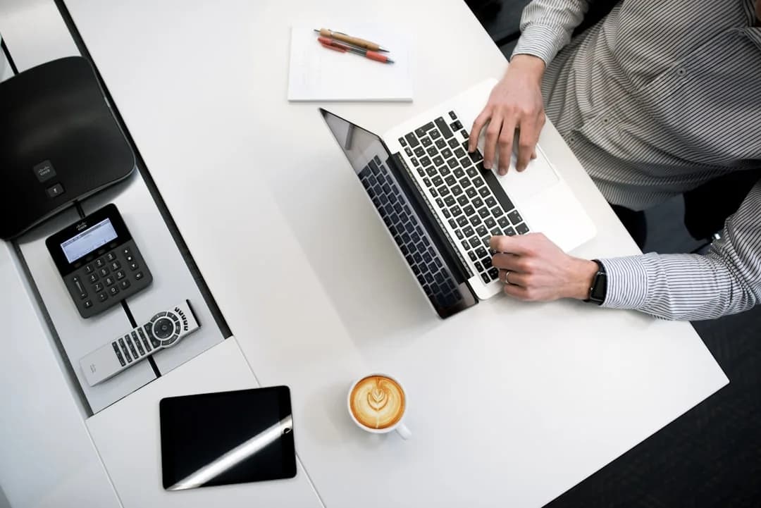 Desk with receipts, bank statements and a laptop showing UK bookkeeping software