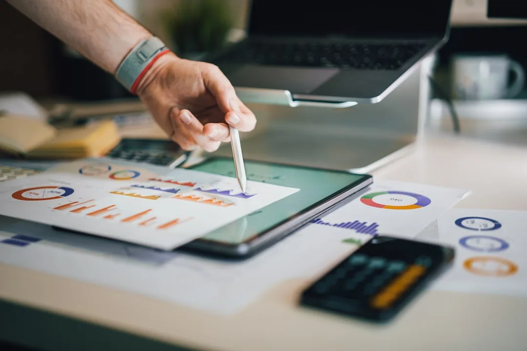 A self-employed UK sole trader at a desk working out their tax bill on a laptop