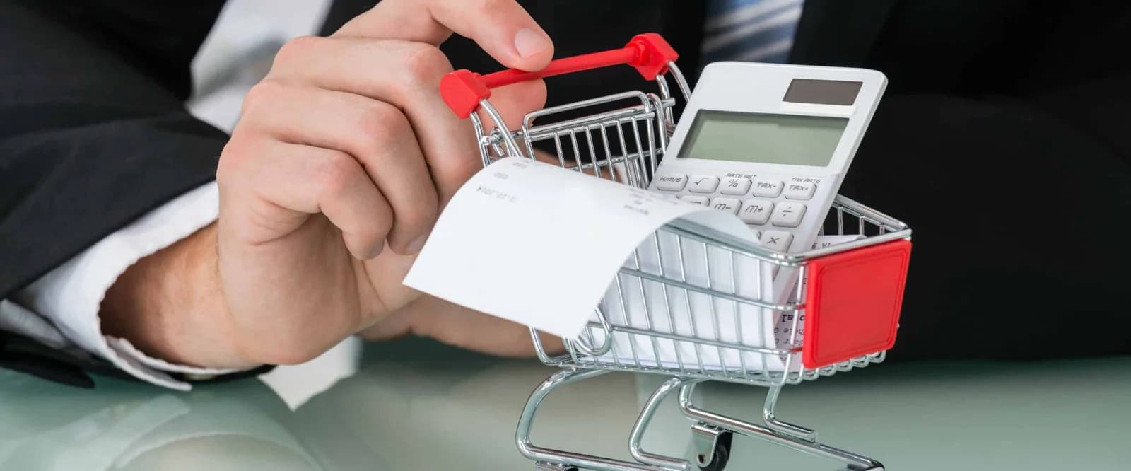 A close-up of a person scanning a credit card through a shopping cart.