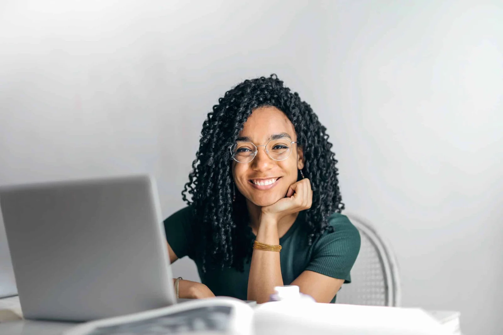 A smiling person working at a desk in a business setting.