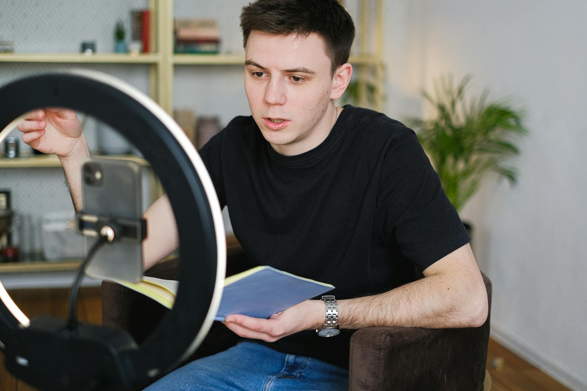 UK content creator filming video at home with a ring light and notebook