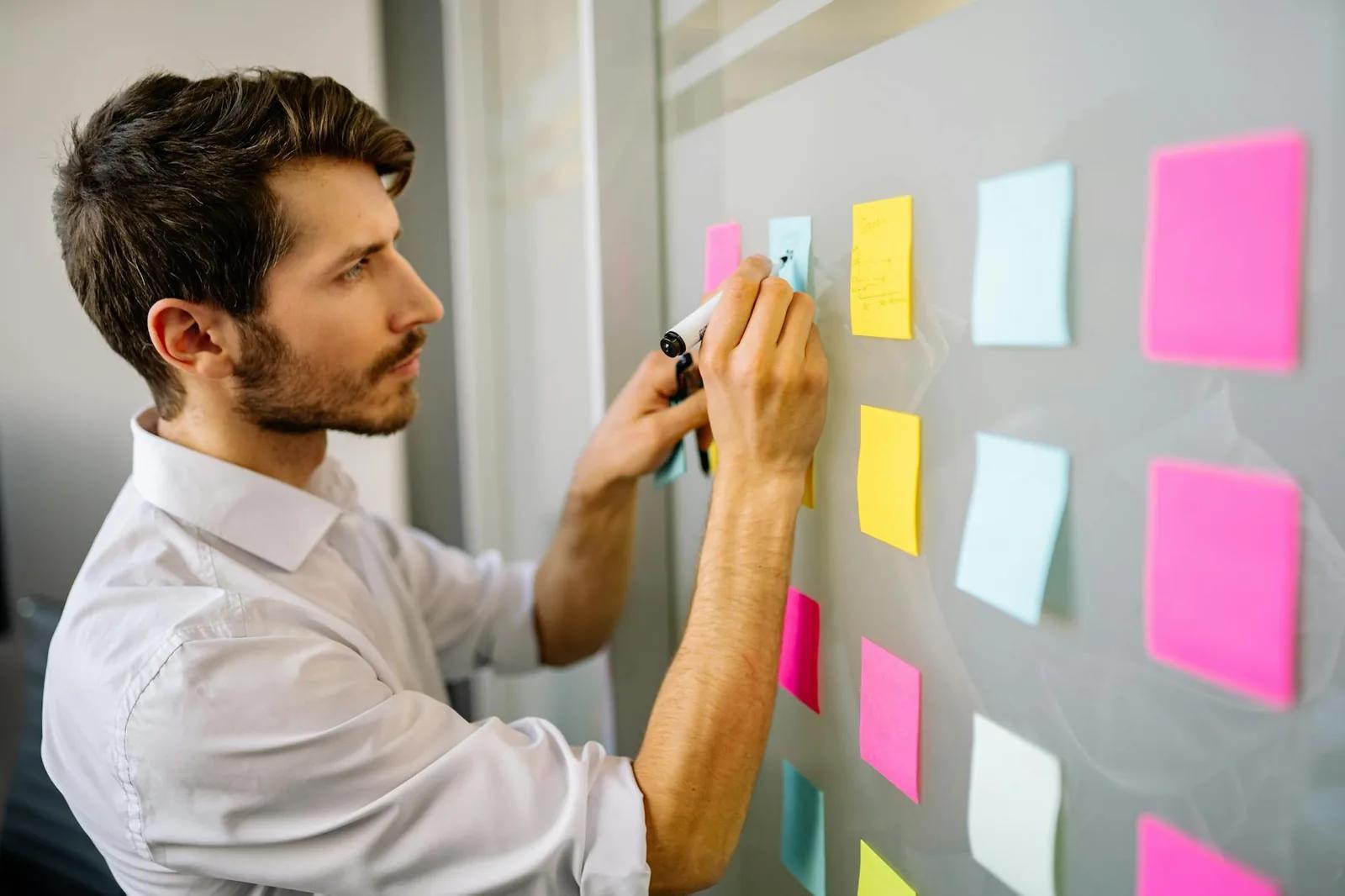 A UK founder reviewing notes and spreadsheets at a desk, sketching out numbers to test a new business idea
