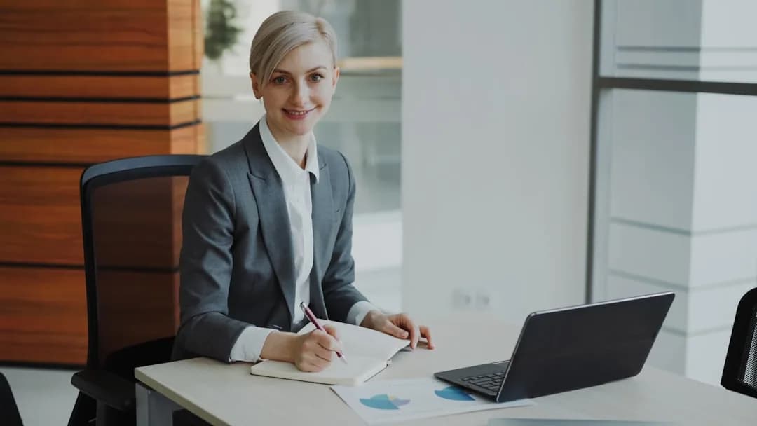 A small business owner reviewing payroll and workplace pension paperwork at a desk