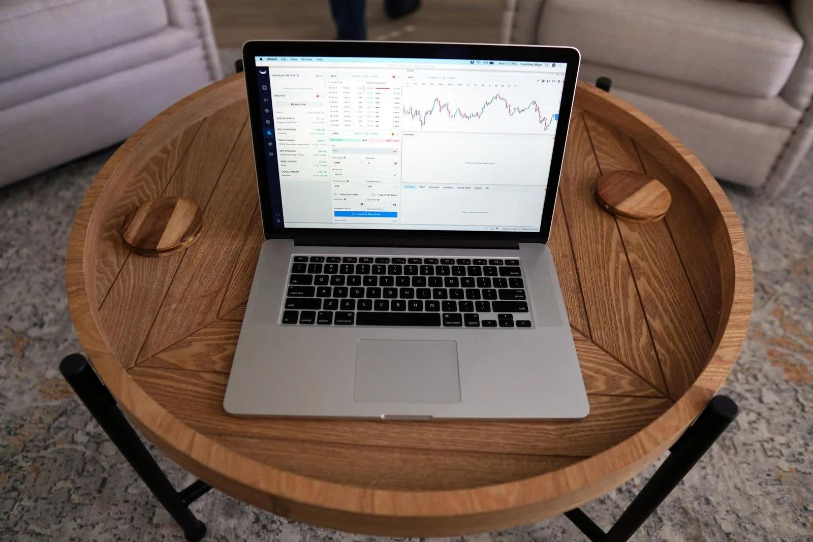 A laptop on a wooden desk displaying an accounting and financial reporting dashboard