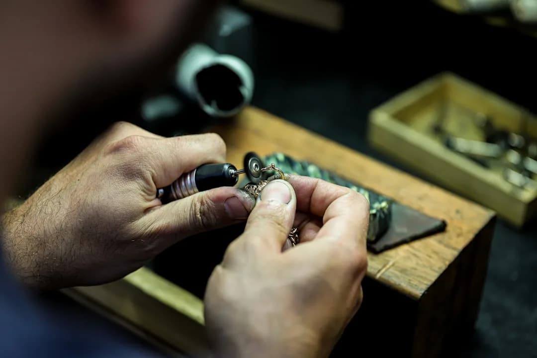 A jeweller at a workbench using precision tools, illustrating equipment that can qualify for capital allowances