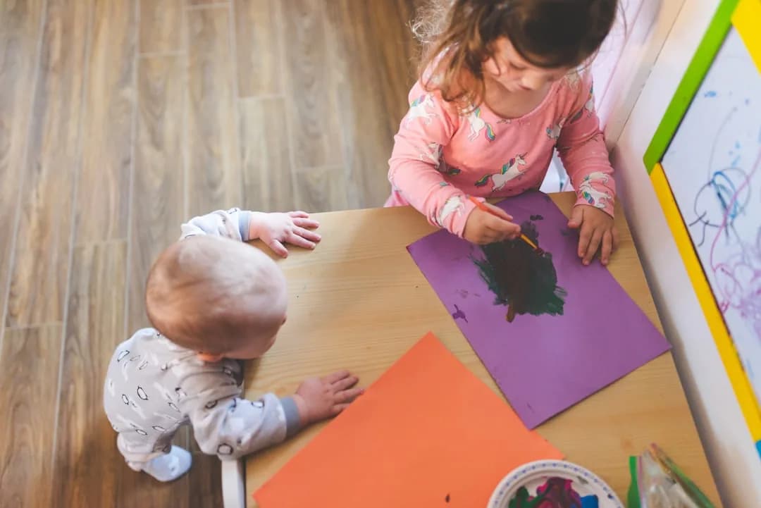 A childminder at a kitchen table working out household running costs for a tax return