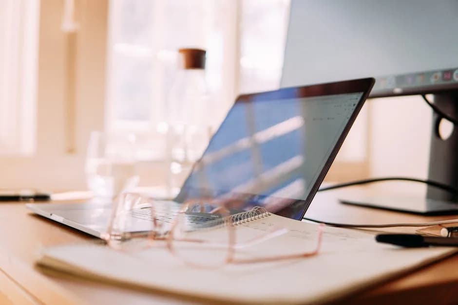 A childminder at a kitchen table with a laptop and receipts preparing a Self Assessment tax return