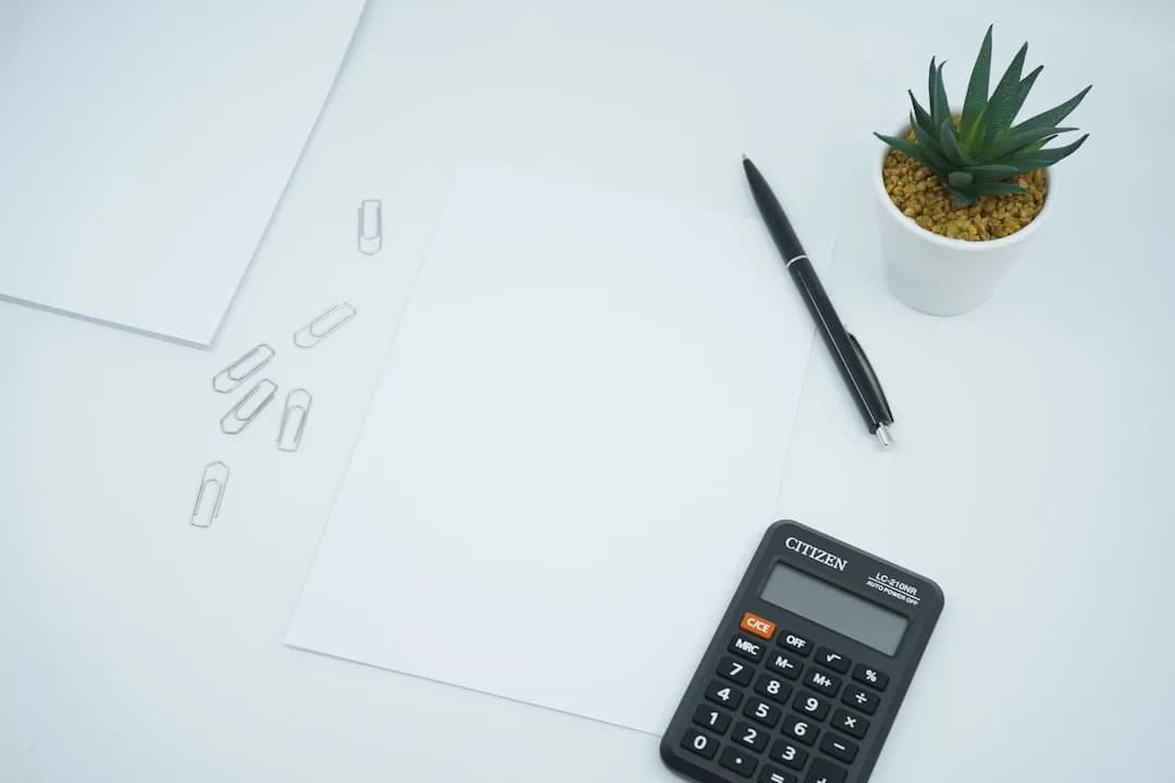 A construction business owner reviewing payroll and subcontractor figures at a site office desk