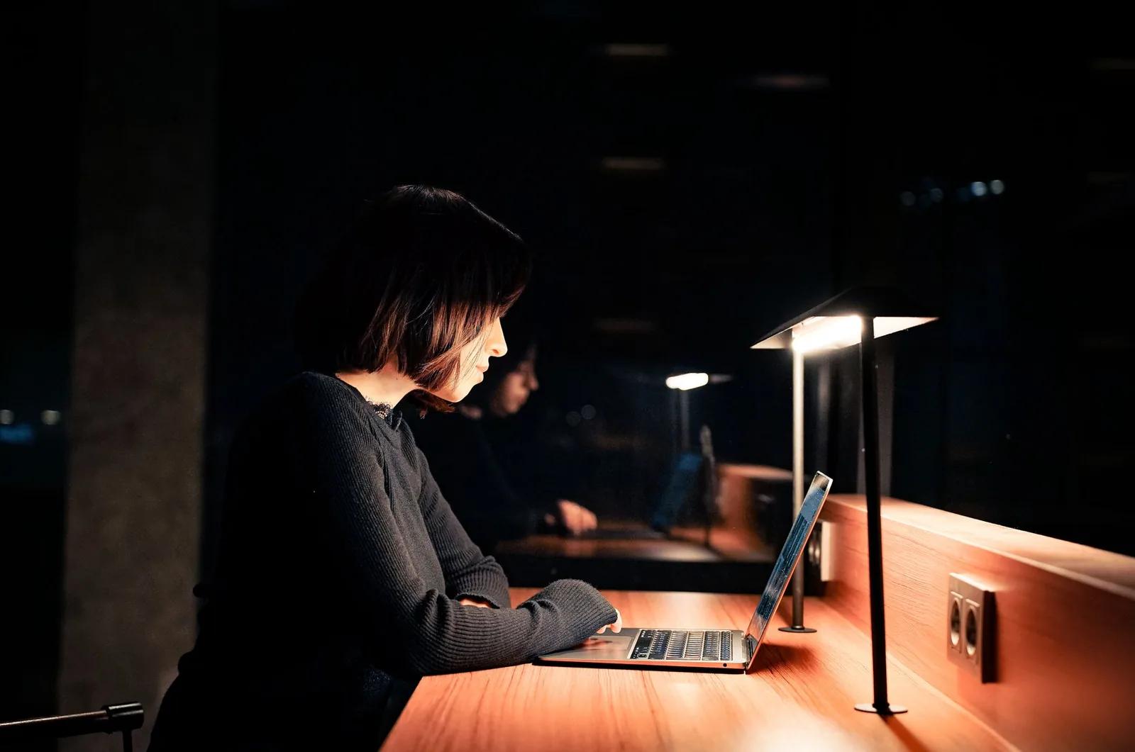 A night shift worker on duty at a workplace reception desk in the early hours