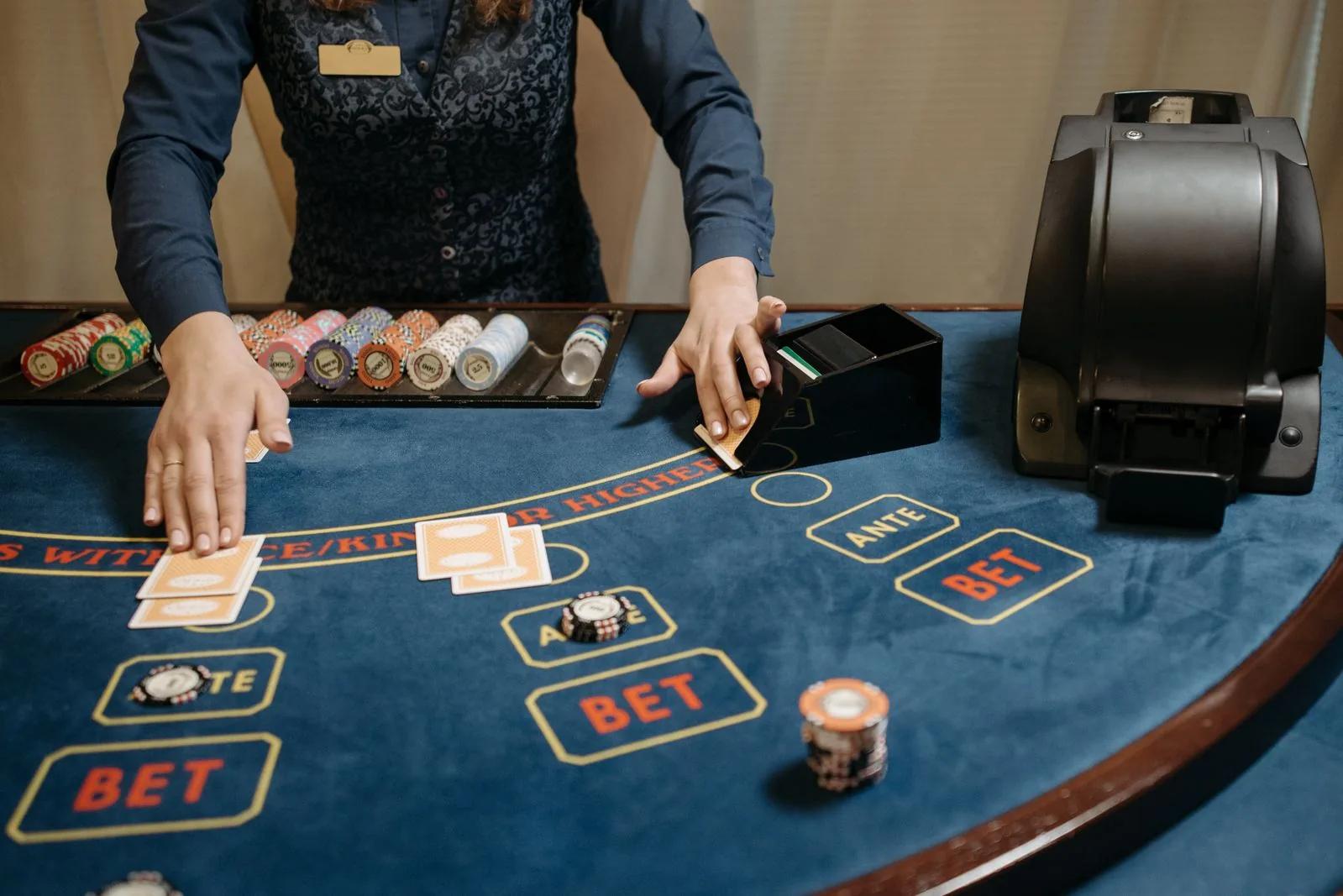 Casino dealer arranging playing cards and chips on a gaming table during a game