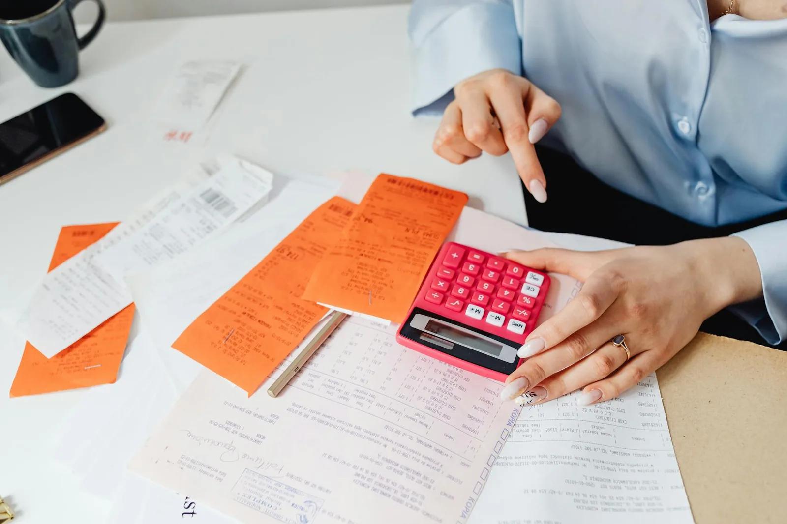 A UK payslip and calculator on a desk, illustrating how frozen tax thresholds increase tax over time
