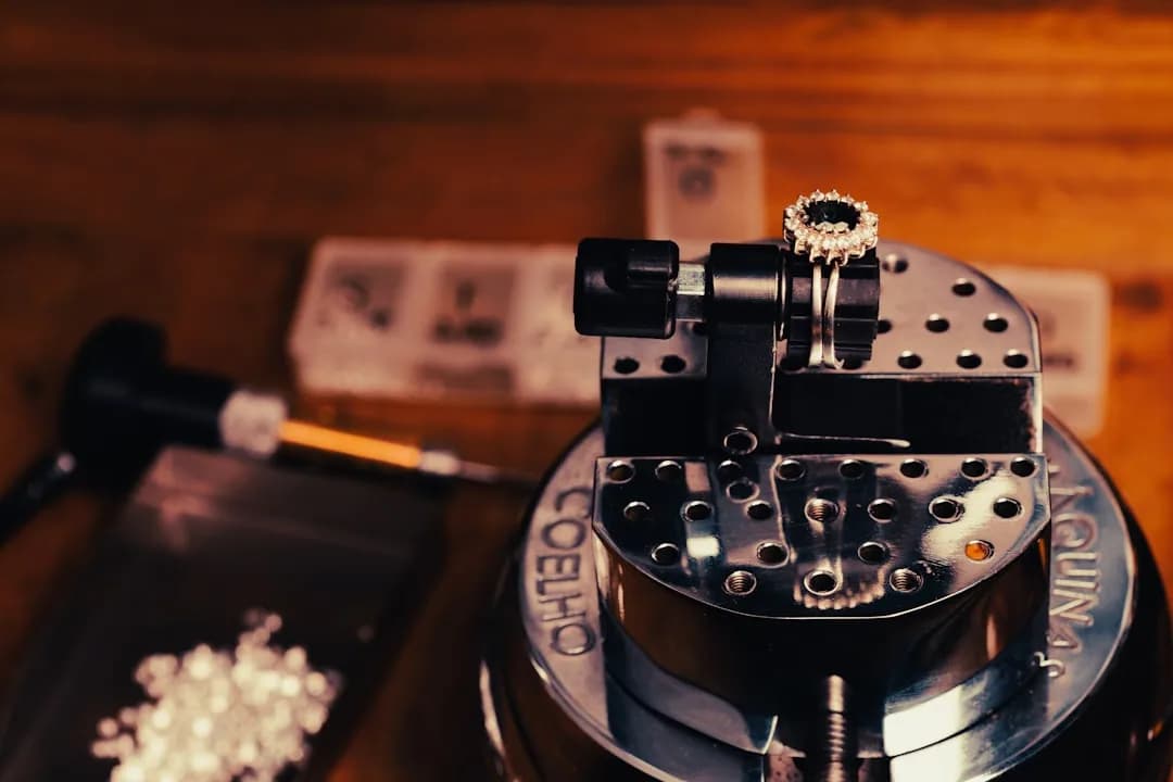 A jeweller examining a hallmarked silver ring at a workbench before sending stock to the Assay Office