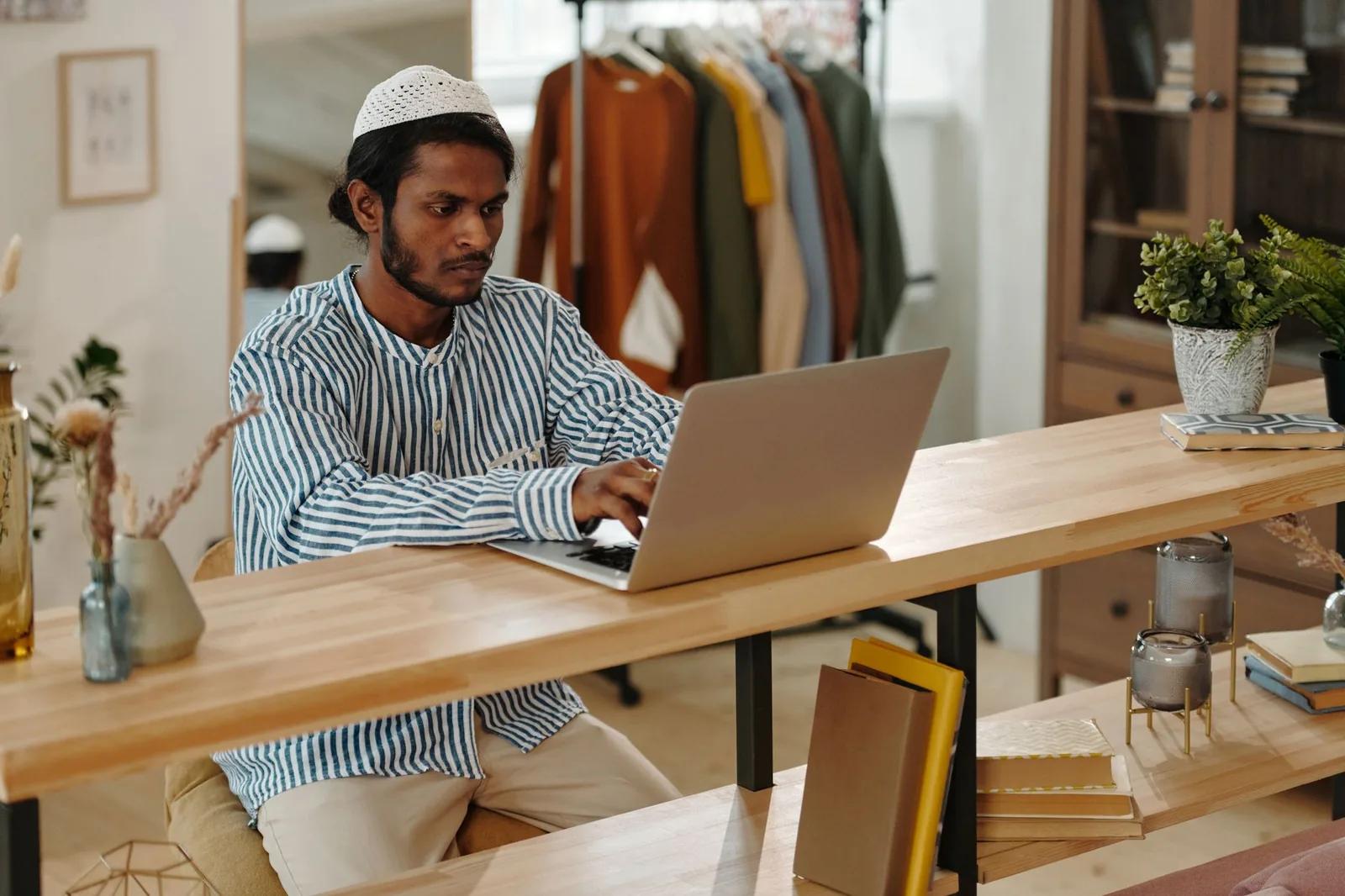 A person signing in to their HMRC personal tax account on a laptop at a home desk to check their tax code