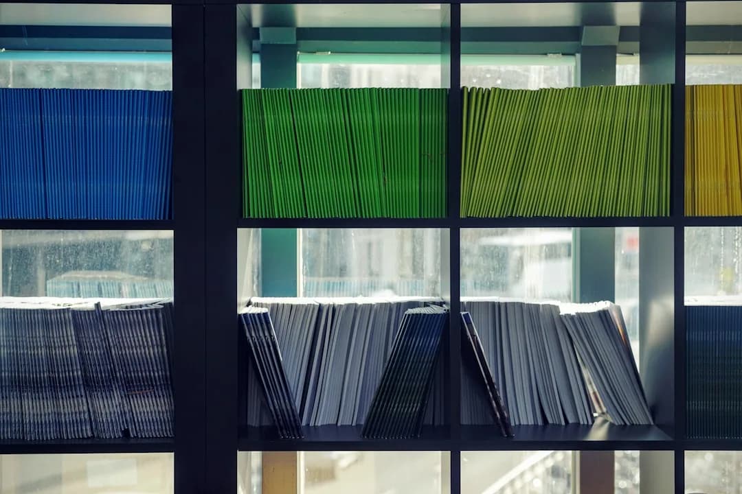 A UK business owner filing labelled folders of invoices and receipts in a home office