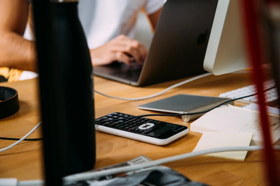 An Amazon FBA seller reviewing import VAT statements and a VAT return at a warehouse desk