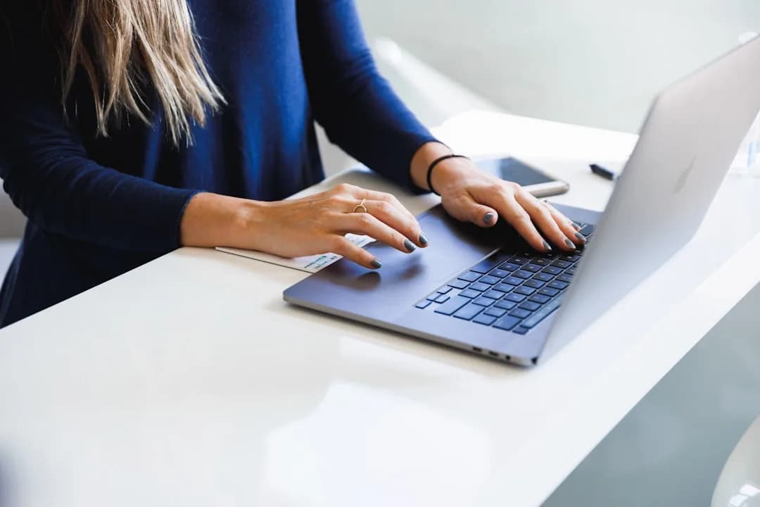A UK landlord at a kitchen table reviewing rental statements and a laptop to disclose income to HMRC