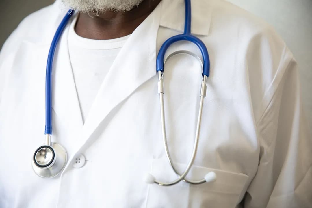 A freelance locum GP reviewing pension contribution paperwork at a desk in a clinical office