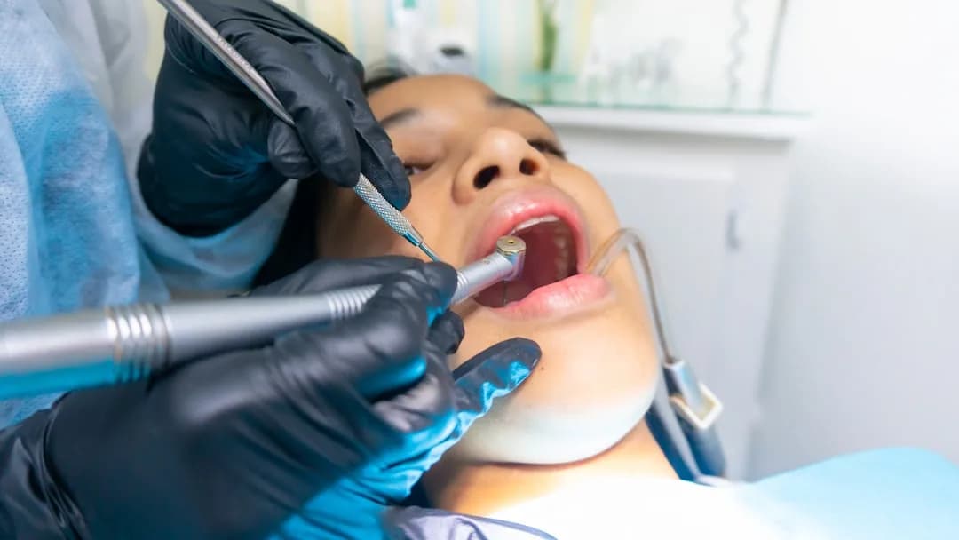 An associate dentist wearing magnification loupes while treating a patient in a UK practice