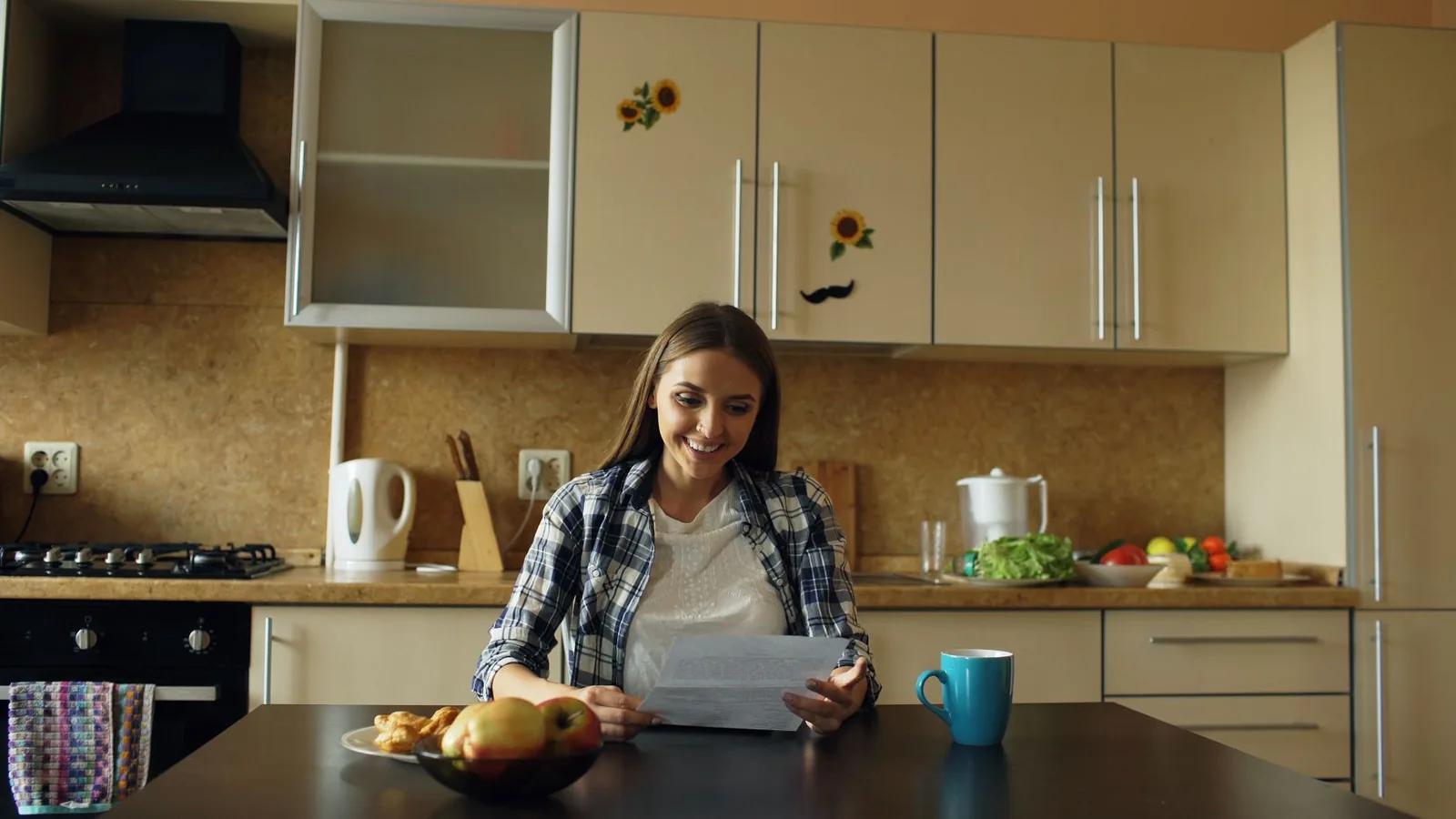 A part-time worker opening an HMRC letter about a pension top-up at a kitchen table