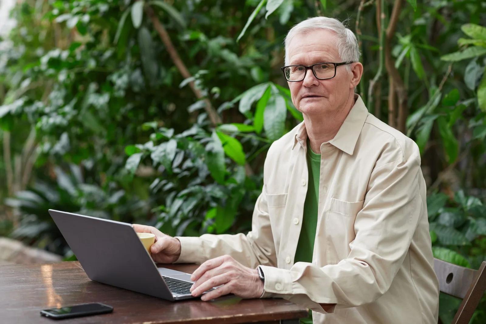 An older self-employed business owner reviewing tax paperwork at a desk, considering National Insurance after reaching State Pension age