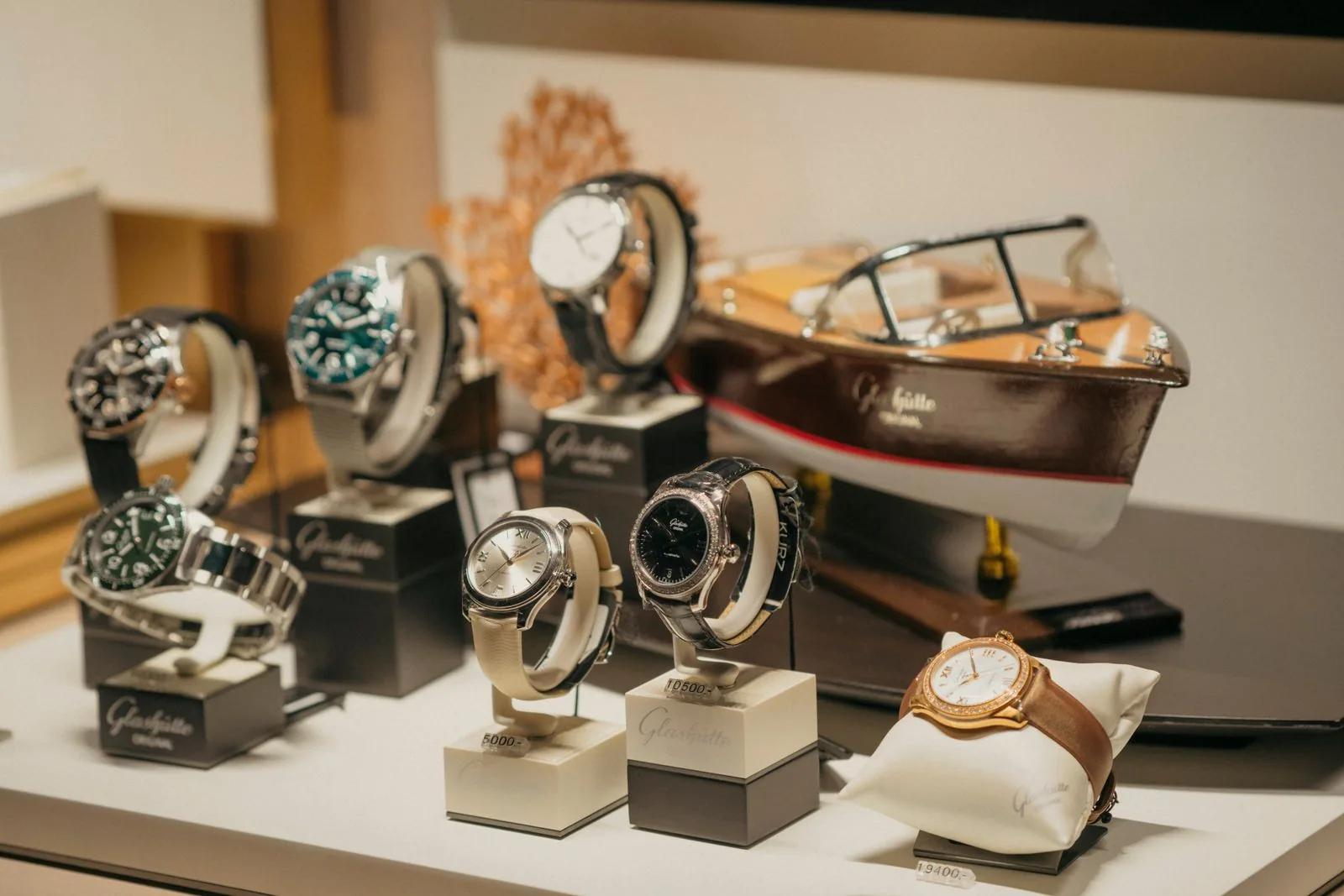 Luxury wristwatches displayed on stands in a premium pre-owned watch retailer