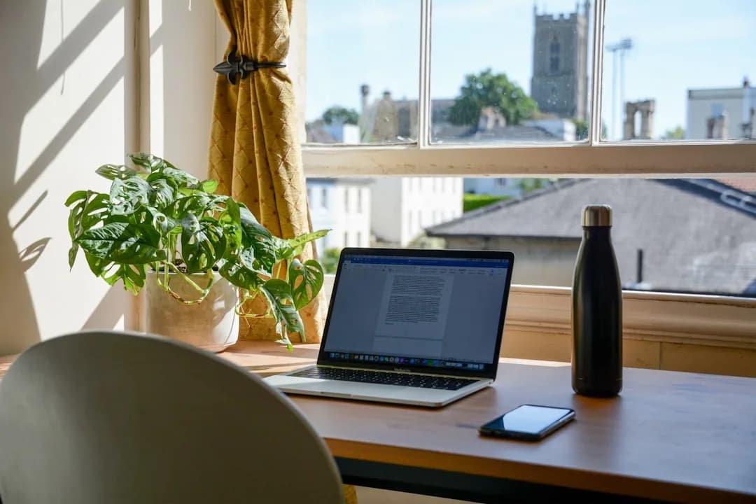 A self-employed designer working at a home office desk, reviewing household bills to claim tax relief