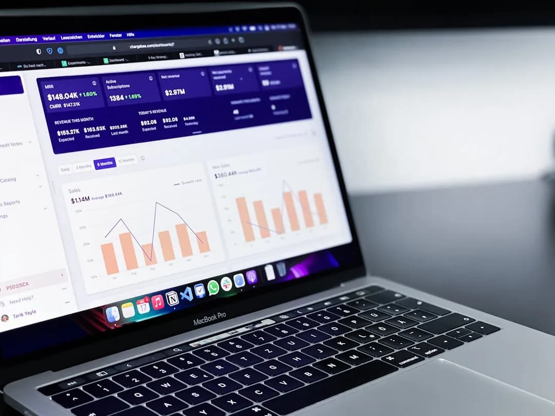 A UK Shopify seller exporting a finance summary report at a laptop to send to their accountant