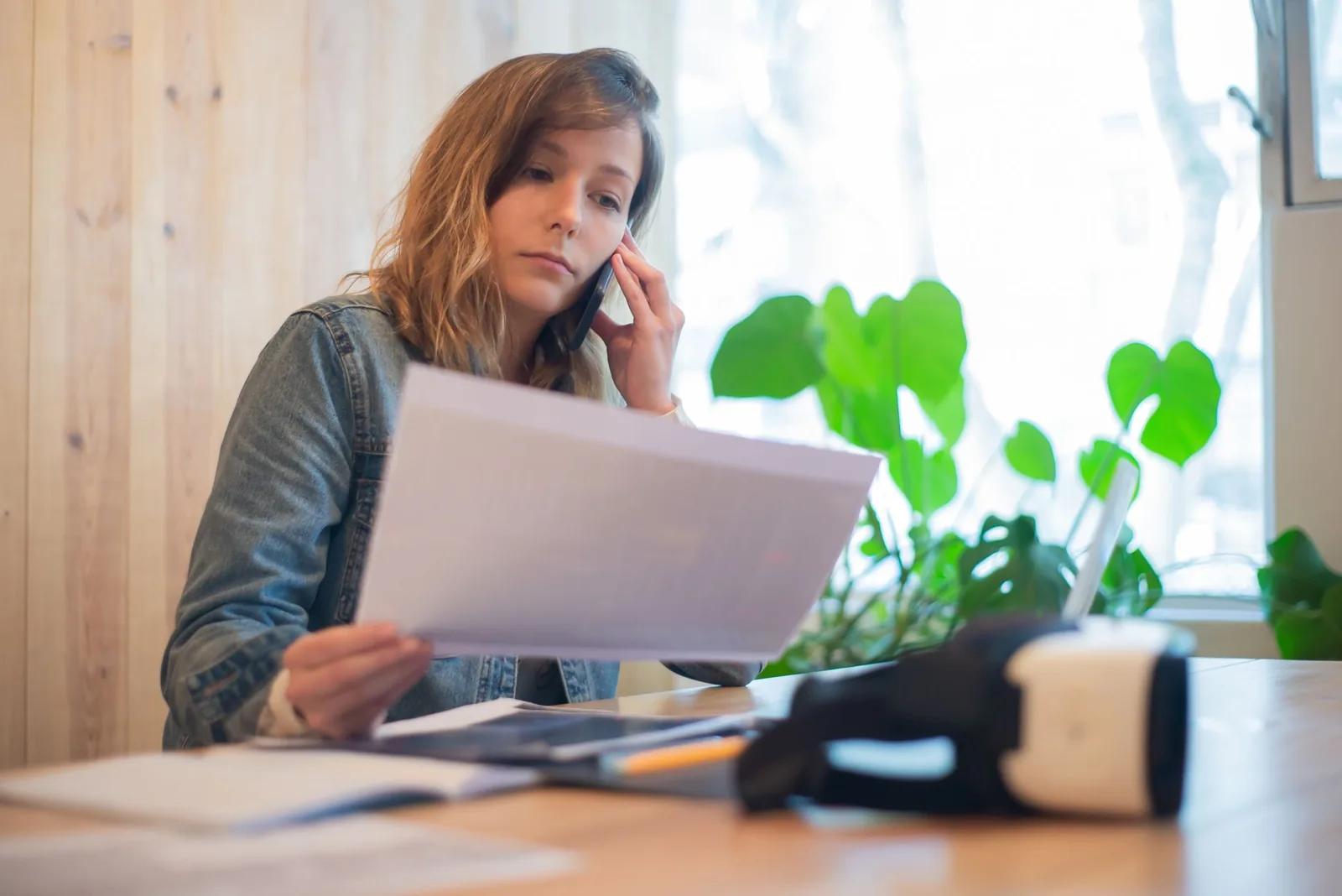 Small business owner reviewing financial paperwork at a desk, considering whether to change accountant