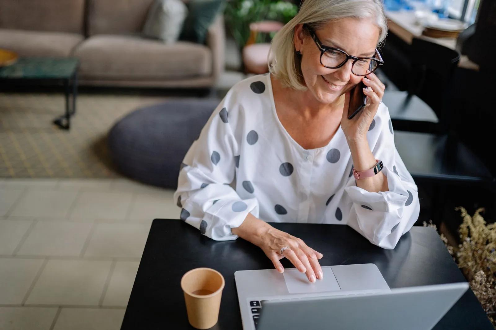 An older couple at a kitchen table reviewing their retirement finances on a laptop