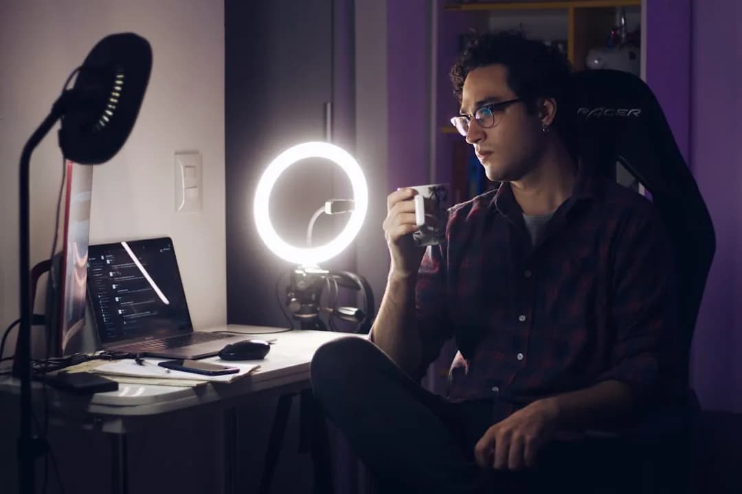 A UK TikTok creator filming with a ring light and camera at a home desk while reviewing expense receipts