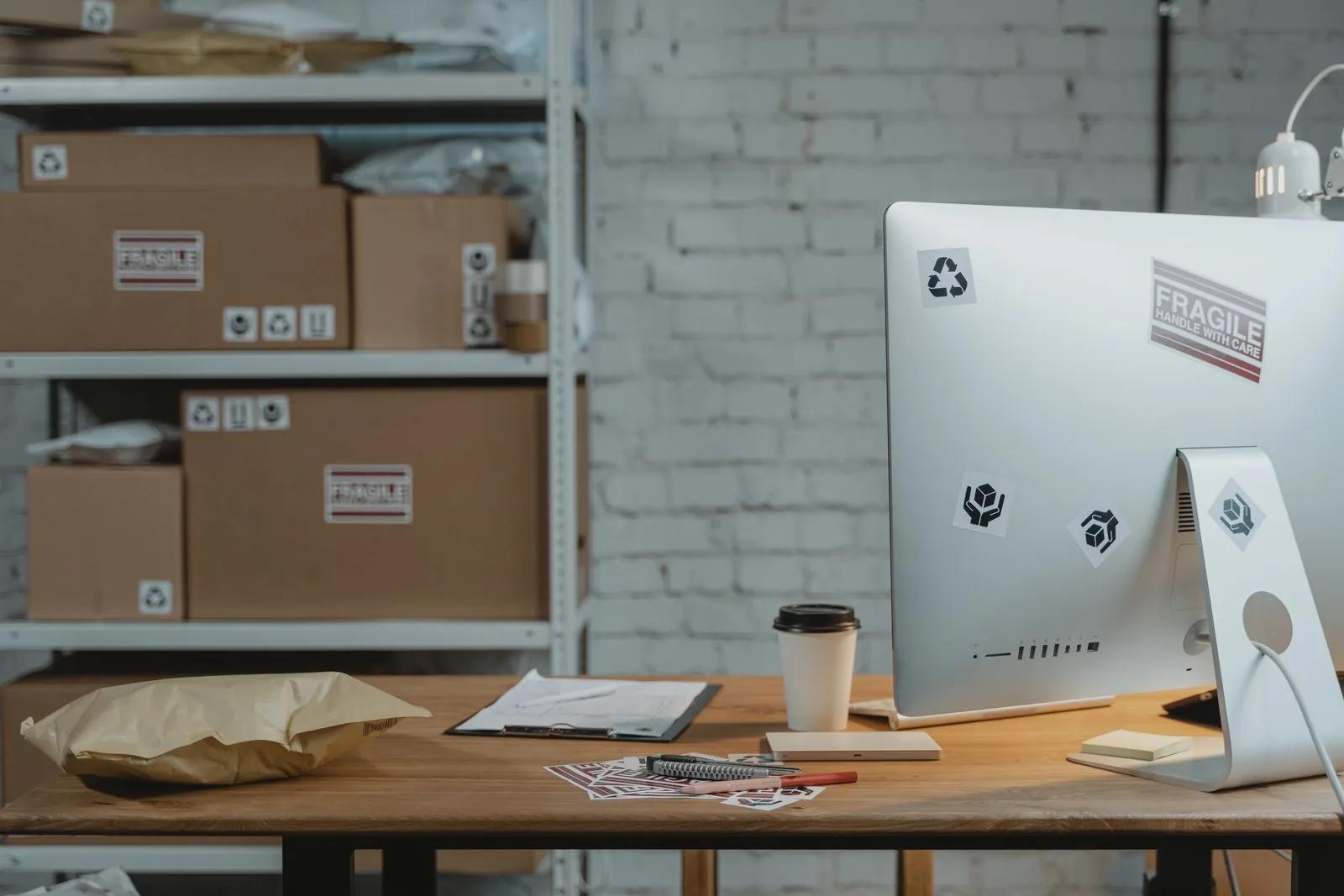 Contemporary office desk with a computer, coffee and parcels ready for dispatch