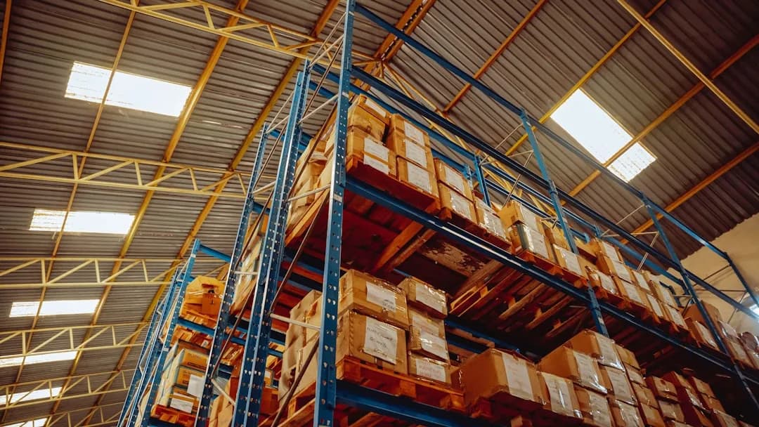 A UK ecommerce seller packing parcels and checking EU VAT, OSS and IOSS rules on a laptop