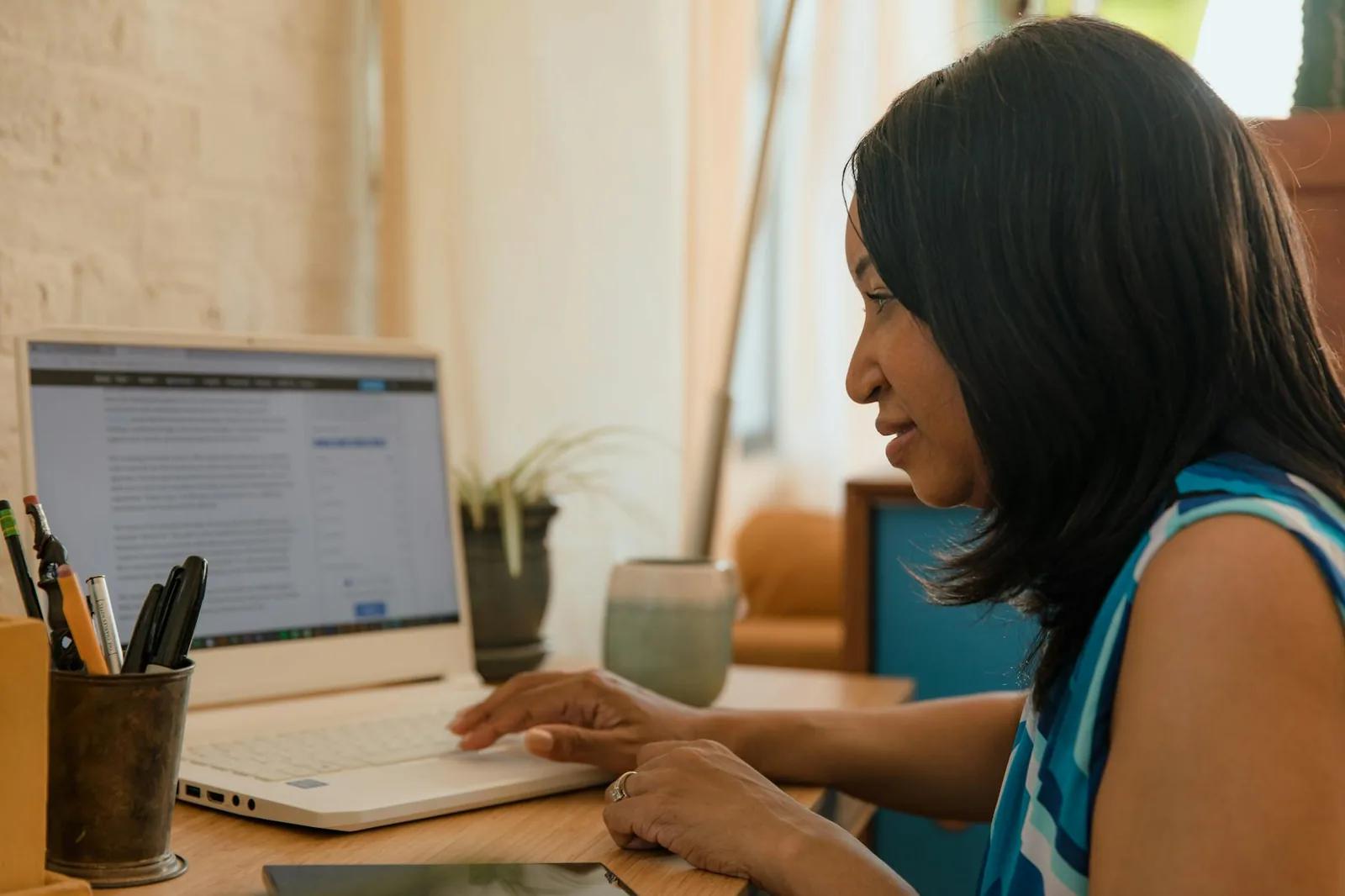 A small business owner reviewing a digital invoice on a laptop with accounting software open