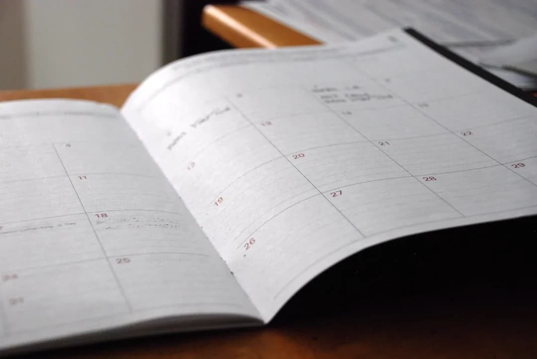 A UK sole trader at a desk checking dates on a calendar before filing a self assessment tax return