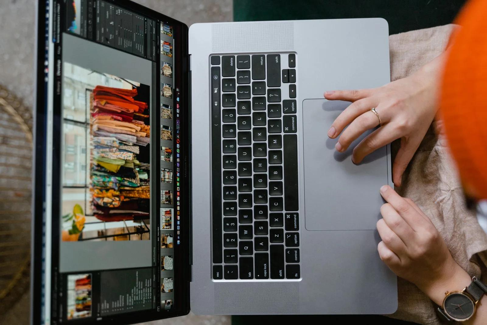 Overhead view of hands using a laptop showing an online shopping platform on screen