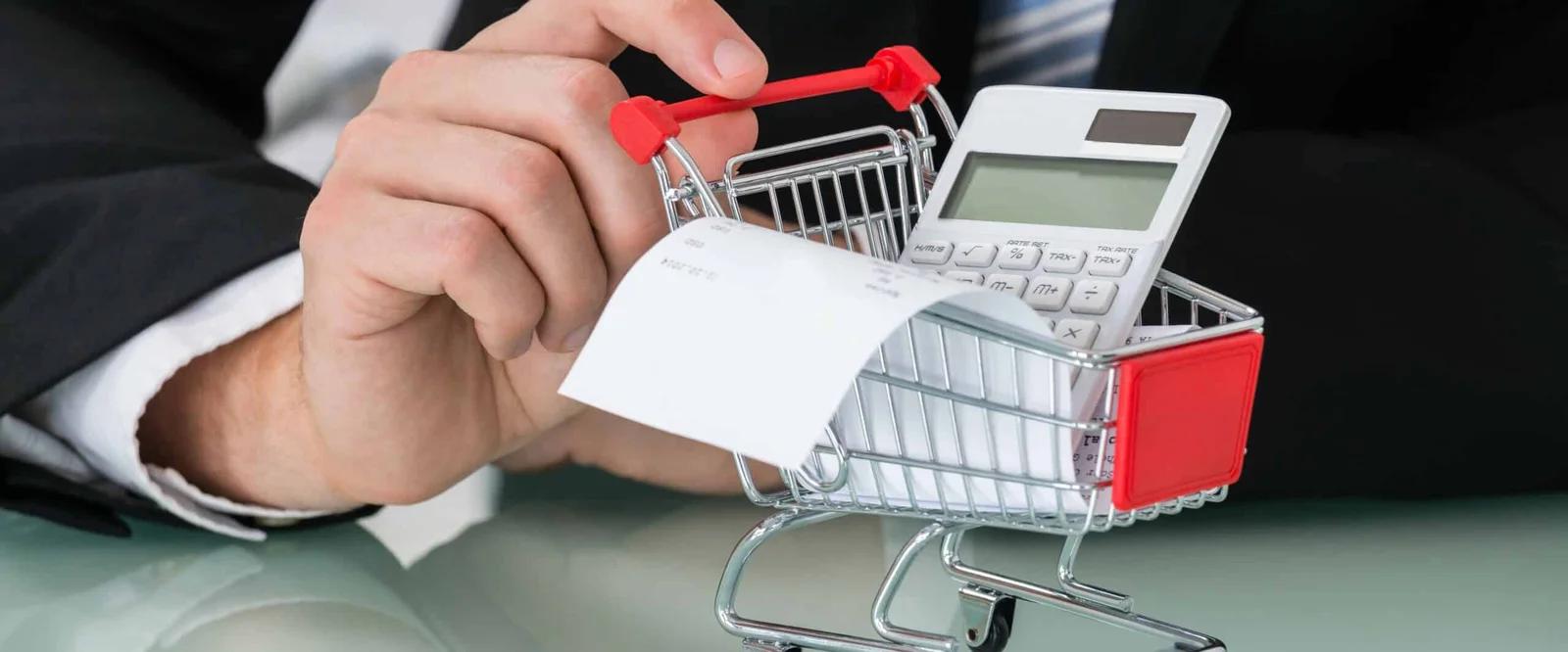 A close-up of a person scanning a credit card through a shopping cart.