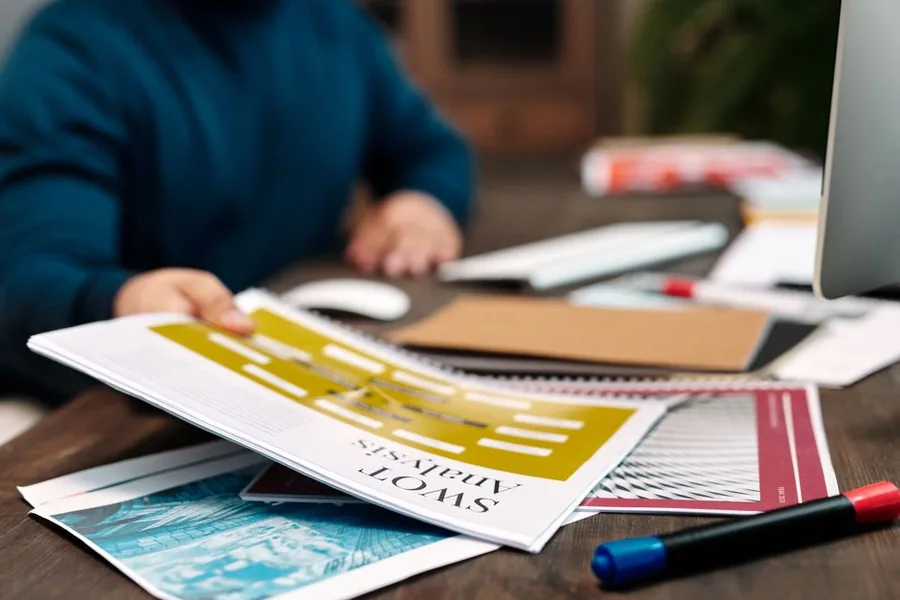 A SWOT analysis printout on a desk beside a laptop and markers, used to pressure-test a new small business idea A SWOT analysis printout on a desk beside a laptop and markers, used to pressure-test a new small business idea