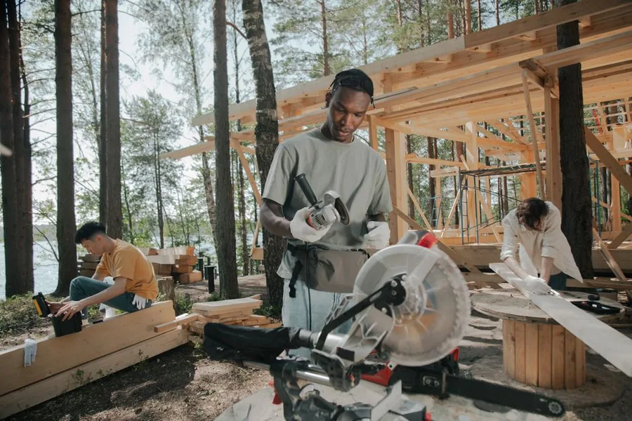 A construction crew framing a new timber-built property on site, the trade work behind CIS and construction VAT