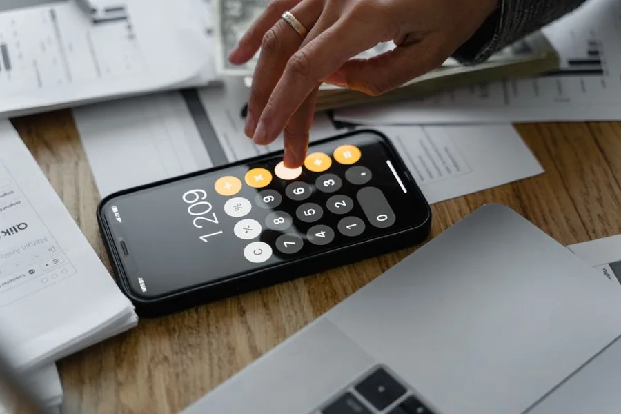 A small limited company director tallying deductible business costs on a calculator beside receipts and a laptop A small limited company director tallying deductible business costs on a calculator beside receipts and a laptop