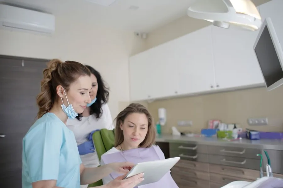 Dental practice staff reviewing figures on a tablet, weighing how the annual allowance taper affects their pension savings