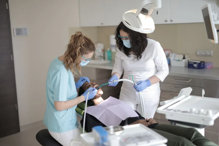 Two dental clinicians treating a patient in a UK practice, the day-to-day work behind an associate dentist's allowable expenses Two dental clinicians treating a patient in a UK practice, the day-to-day work behind an associate dentist's allowable expenses