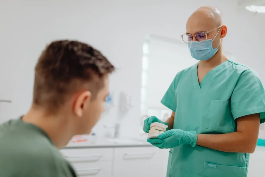 An associate dentist reviewing a dental model with a colleague in a modern UK practice surgery An associate dentist reviewing a dental model with a colleague in a modern UK practice surgery