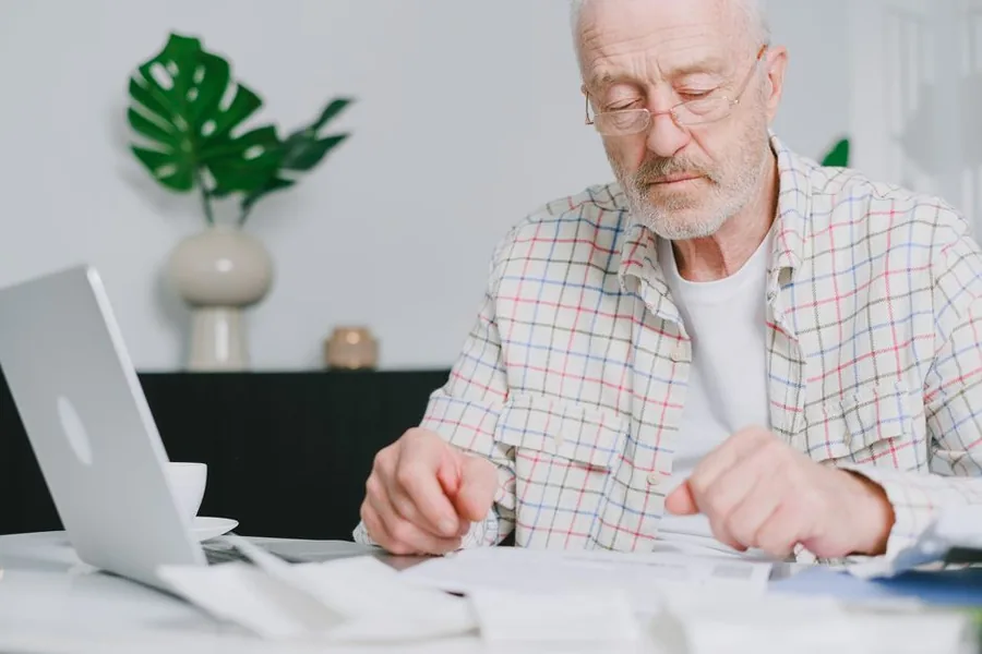 A small business owner going through workplace pension paperwork with an adviser during an auto-enrolment planning session