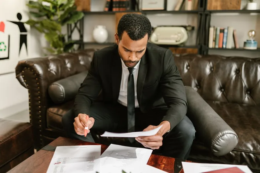 A UK sole trader reviewing accounts and tax paperwork to align their books with the new tax-year basis A UK sole trader reviewing accounts and tax paperwork to align their books with the new tax-year basis