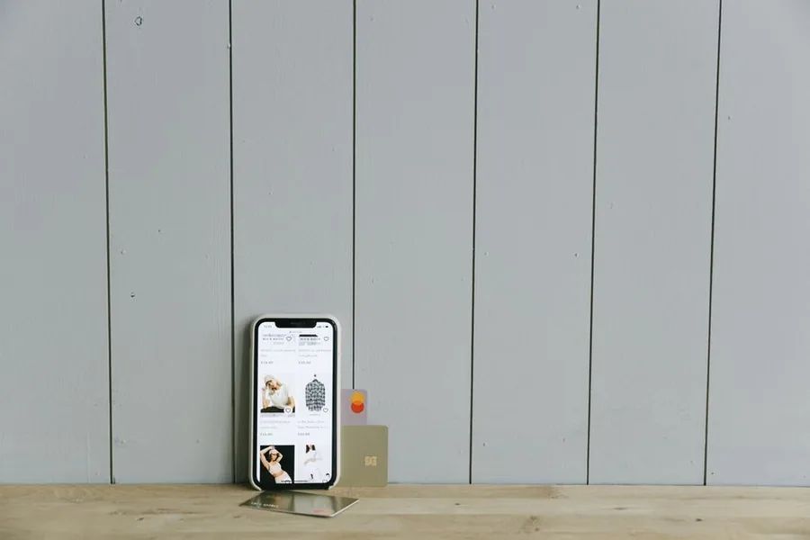 An online store open on a smartphone next to a payment card, the everyday setup behind a UK ecommerce seller's takings