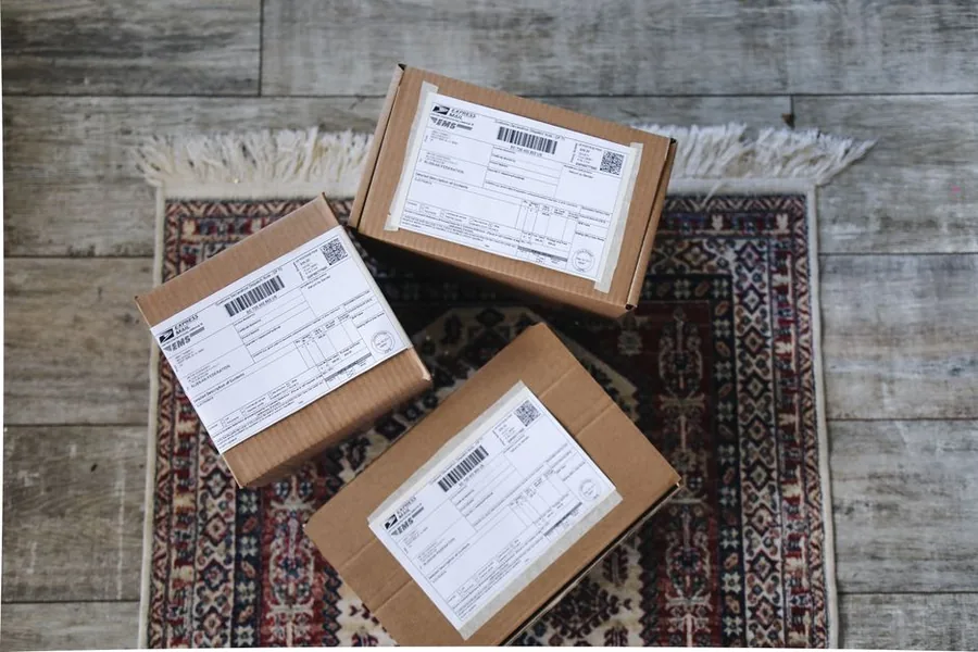An online seller handing over parcels packed and labelled ready to dispatch to customers An online seller handing over parcels packed and labelled ready to dispatch to customers