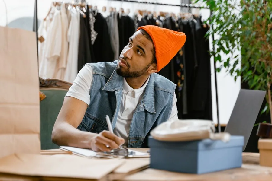 An independent shop owner going over paperwork at his counter, the kind of small business that may qualify for BADR when sold An independent shop owner going over paperwork at his counter, the kind of small business that may qualify for BADR when sold