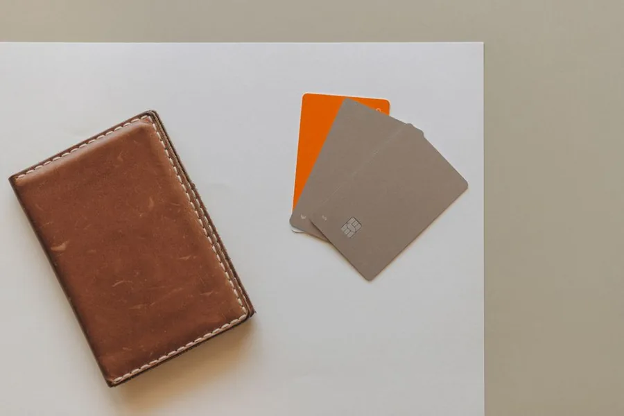 Premium metal business bank cards fanned beside a leather cardholder, the type of account that often carries a monthly fee Premium metal business bank cards fanned beside a leather cardholder, the type of account that often carries a monthly fee