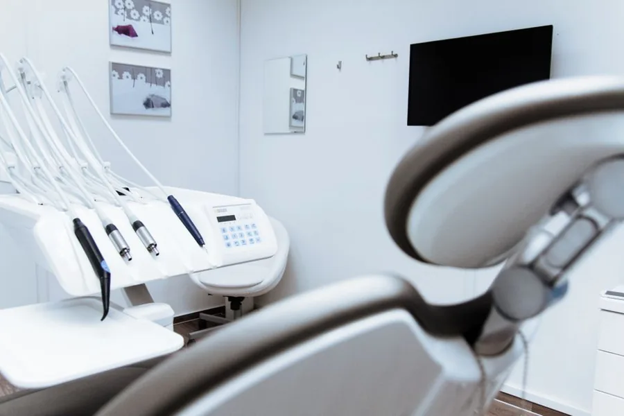 A dentist reviewing practice paperwork in a modern UK surgery while weighing up the purchase